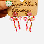 Pink glitter stud earrings with marbled bow in pink, red, white, gold tones