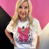 White tee with polka dot pumpkin, sparkling trim, oversized pink bow, and jeweled center.
