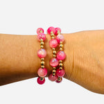 Water resistant pink beaded bracelet set with gold spacers and elastic stretch for everyday wear.