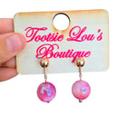 Pink marbled bead stud earrings with glossy finish and gold ball studs.
