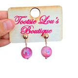Pink marbled bead stud earrings with glossy finish and gold ball studs.
