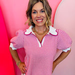 Pink gingham puff sleeve top with scallop trim and split V-neck.