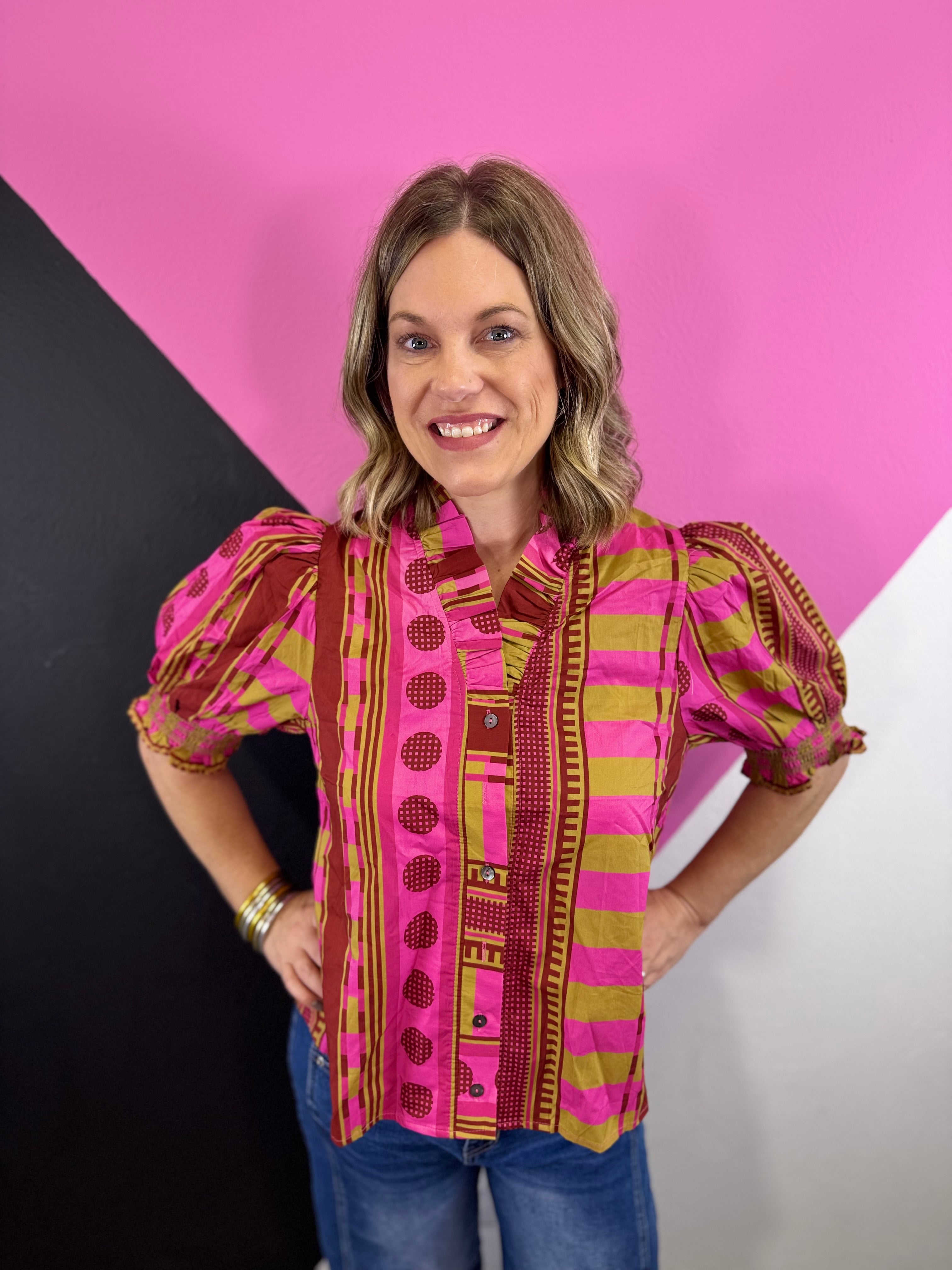 Pink mixed print blouse with ruffled neckline, button front, and smocked short puff sleeves.