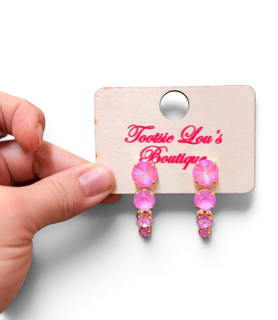 Pink opaque crystal drop earrings with four graduating round stones.