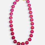 Pink opaque crystal tennis necklace with iridescent stones, gold-tone settings, and magnetic clasp.