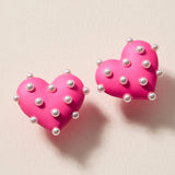 Pink matte heart stud earrings covered in faux pearls for a cute, bold statement look.