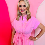 Soft pink peplum blouse with drawstring waist and cap sleeves.