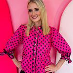 Pink polka dot babydoll top with tie sleeves and button front.