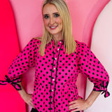 Pink polka dot babydoll top with tie sleeves and button front.