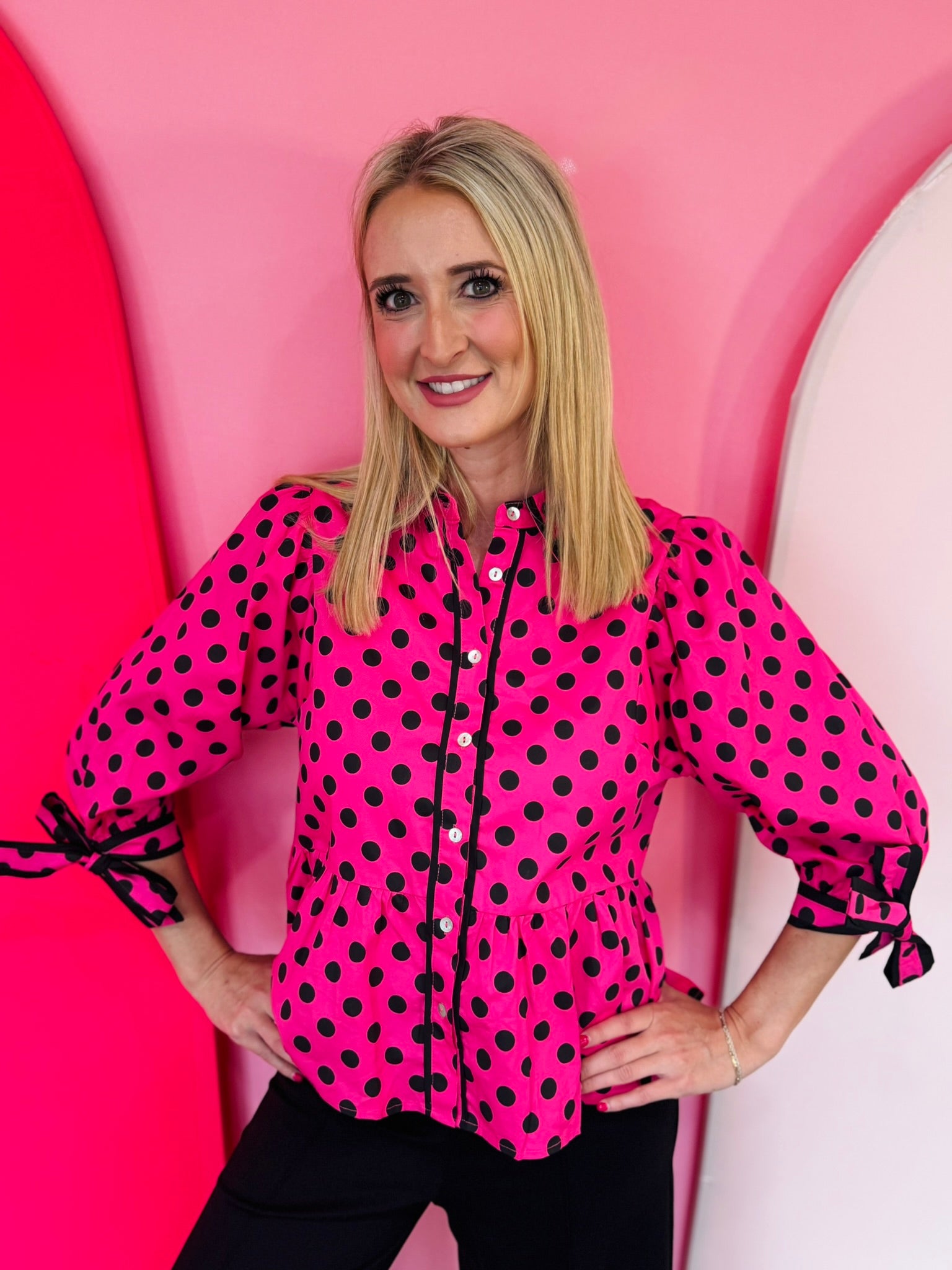 Pink polka dot babydoll top with tie sleeves and button front.