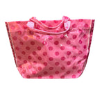 Light pink PVC tote bag with dark pink polka dots, sturdy handles, and striped sides.