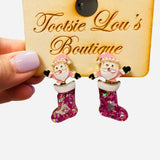 Santa stud earrings with pink glitter stocking, gold accents, and pearl details on hat.