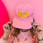 Pink XOXO embroidered baseball cap with gold lettering and adjustable snapback closure
