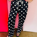 Black jogger pants with cream polka dot print and relaxed fit.