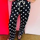 Black jogger pants with cream polka dot print and relaxed fit.