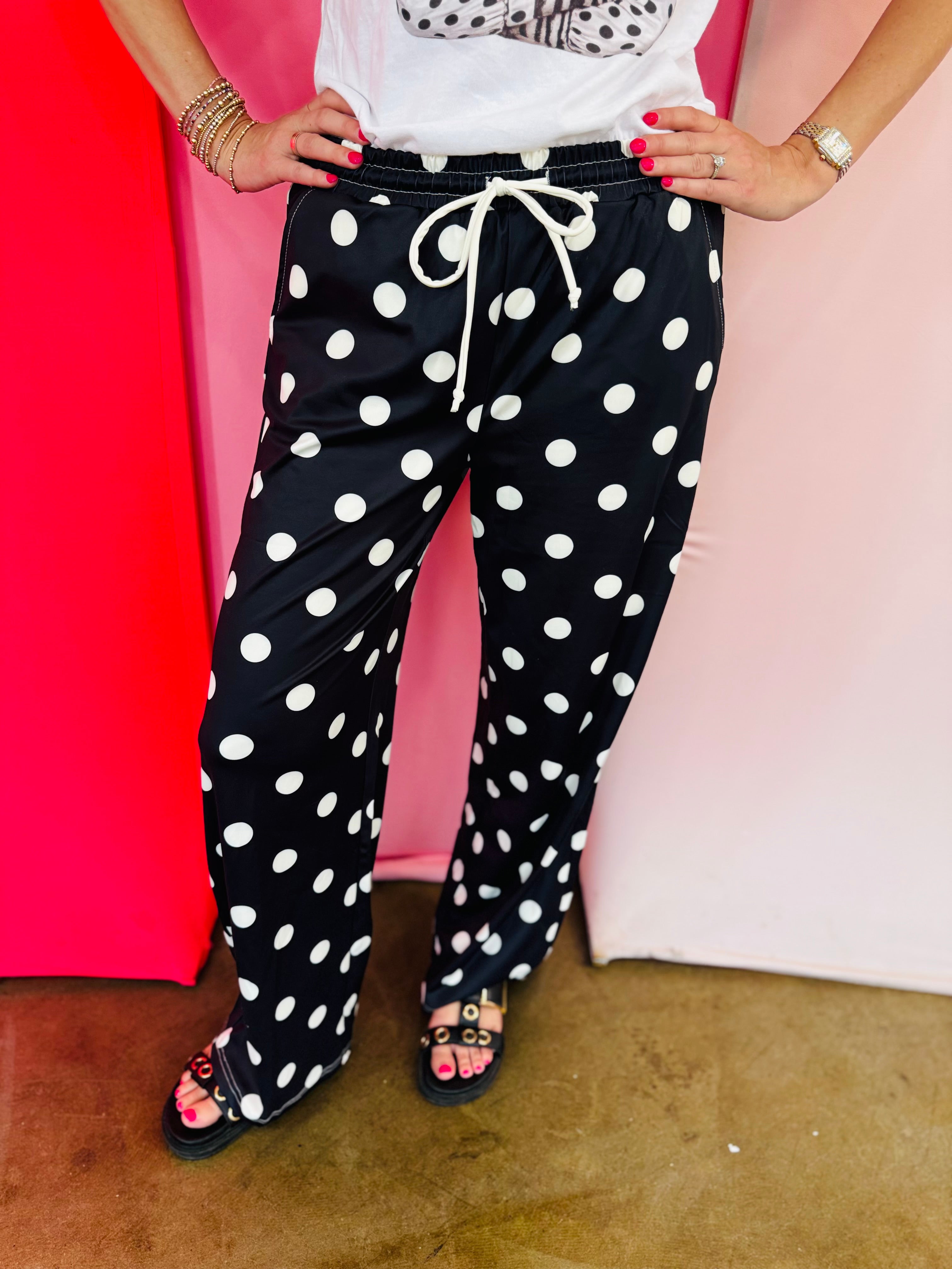Black jogger pants with cream polka dot print and relaxed fit.