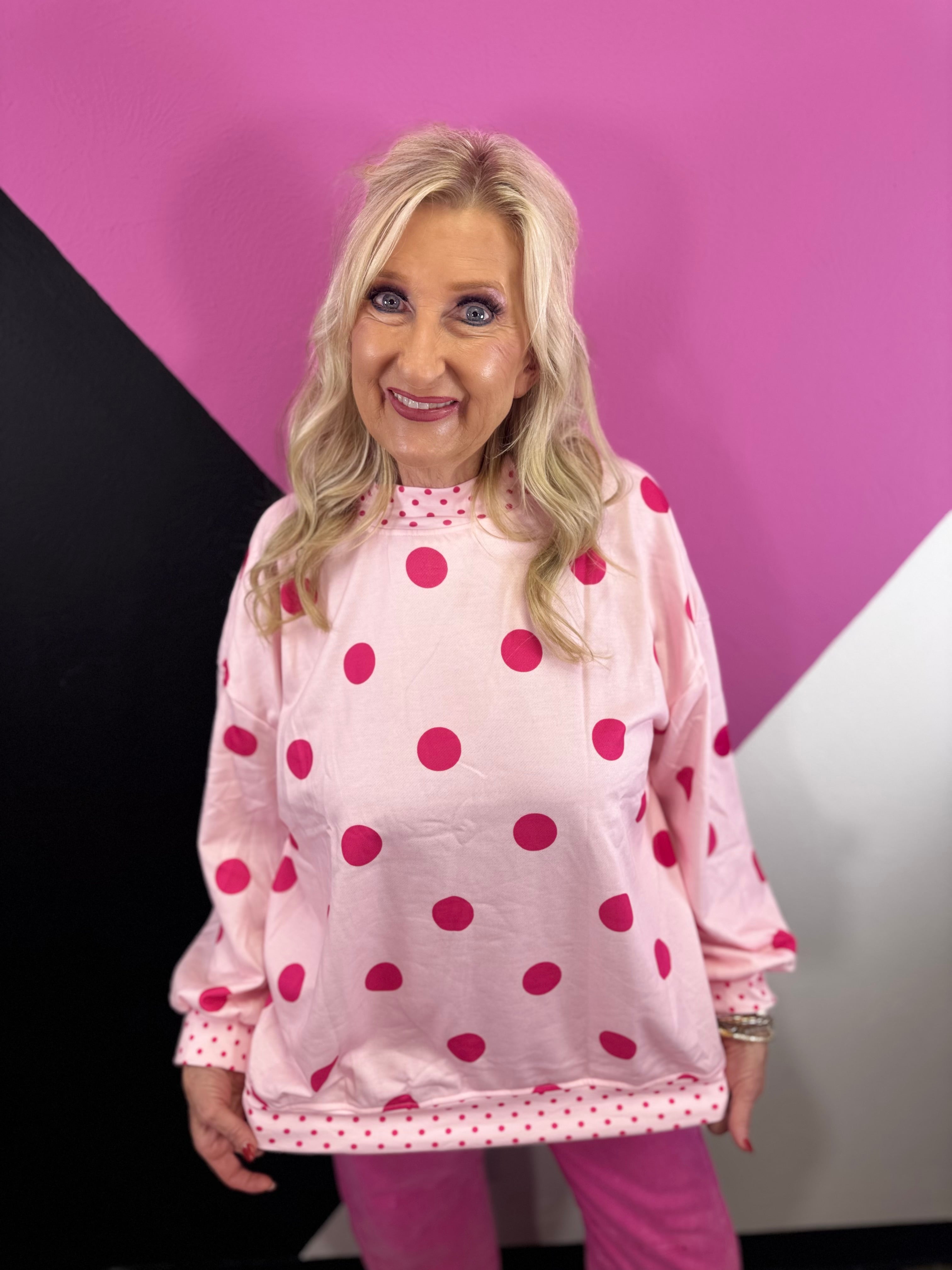 Light pink mockneck pullover with oversized hot pink polka dots and contrast trim.