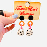 Black stud earrings with orange pink links and spotted black white drops.
