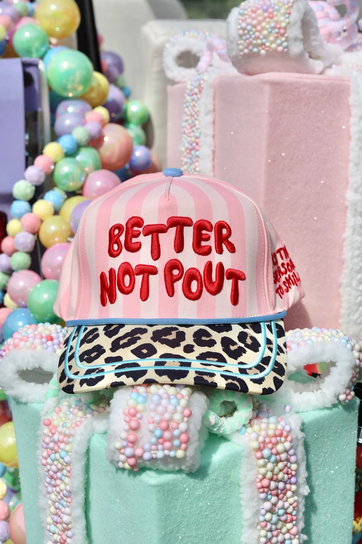Pink striped Better Not Pout Christmas hat with leopard bill and teal trim.