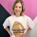 Pink game day tee with oversized brown football, striped details, polka dots, and bold lettering.