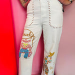 White wide-leg crop jeans with cowboy artwork and Western-inspired blanket stitch details.