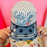 Pinstripe baseball hat with Let’s Go Kid embroidery and blue polka dot brim