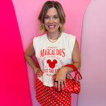 Cream muscle tank with red magical theme park graphic and relaxed fit.