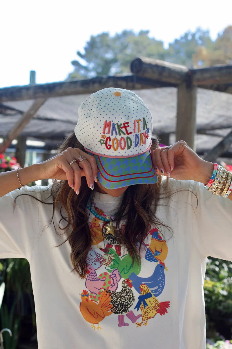 White hat with rainbow Make It a Good Day embroidery and colorful patterned bill.