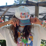 White hat with rainbow Make It a Good Day embroidery and colorful patterned bill.