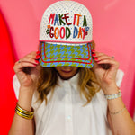 White hat with rainbow Make It a Good Day embroidery and colorful patterned bill.