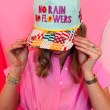 Pastel green hat with floral “No Rain No Flowers” embroidery and patchwork brim.