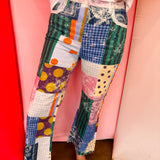 Colorful patchwork jeans with mixed prints, oversized pockets, lace accents, and raw hem details.