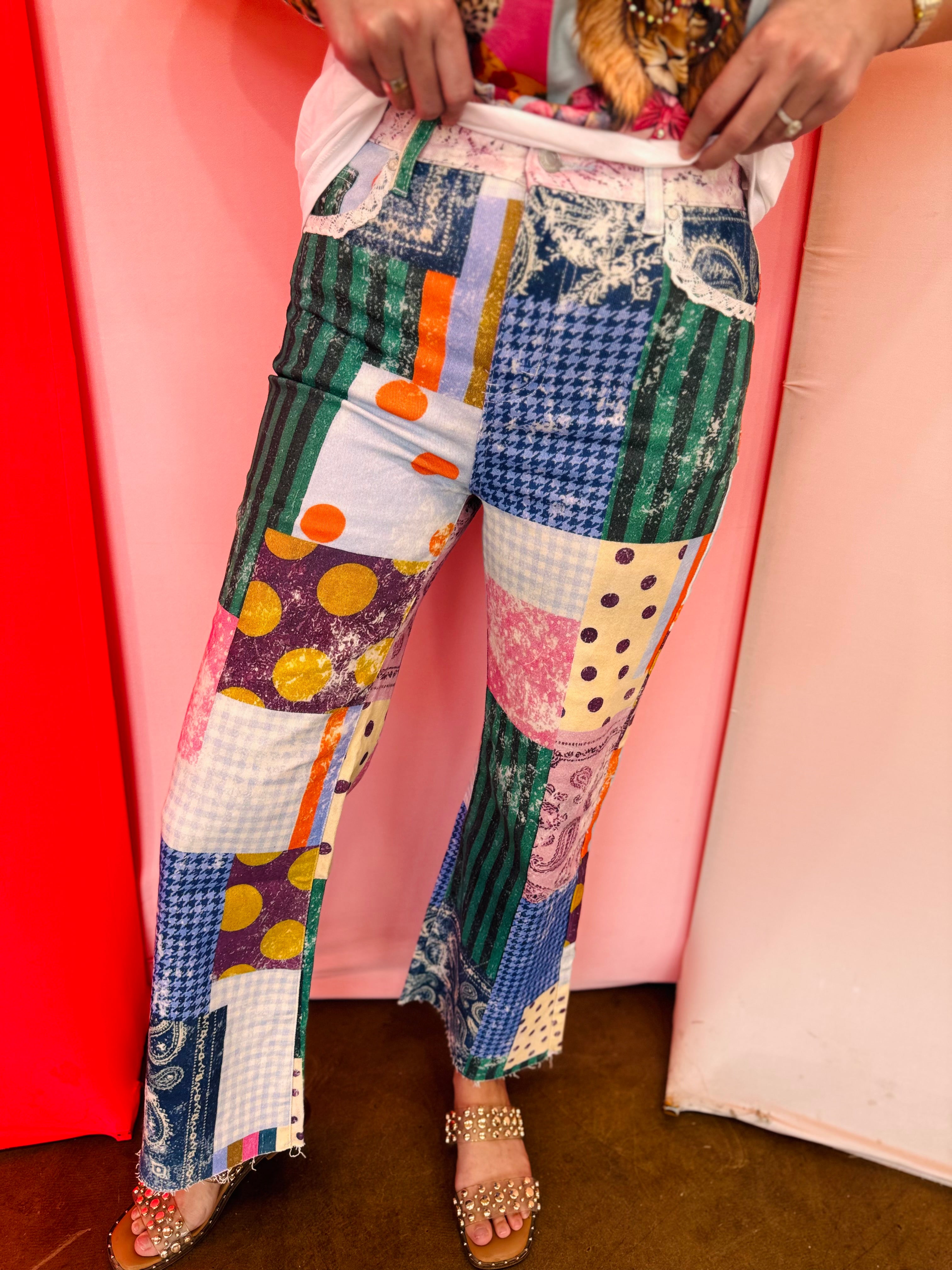Colorful patchwork jeans with mixed prints, oversized pockets, lace accents, and raw hem details.