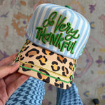 Blue striped hat with green So Very Thankful embroidery, leopard bill, and gold piping.