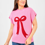 Pink knit sweater with bold textured red bow, crew neckline, and ribbed cuffs.