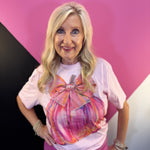 Pink tee with colorful pumpkin, oversized bow, and rhinestone accents.