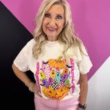 Colorful pumpkin graphic tee with playful ghosts, bats, pink stripes, and checkered details.