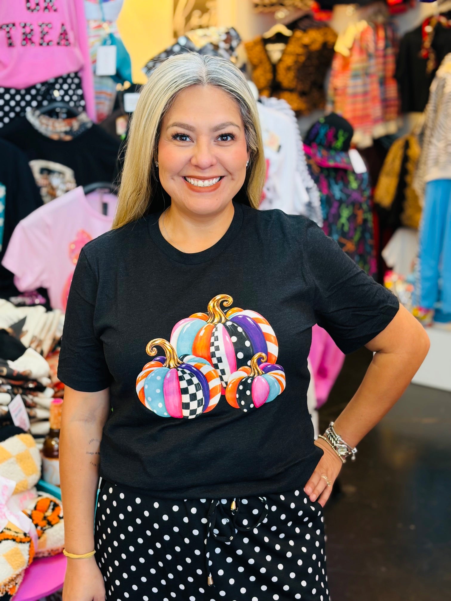 Black tee with colorful pink, turquoise, orange, and purple patterned pumpkins.