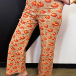 Latte stretch denim pants with orange pumpkins, autumn florals, and cropped wide-leg flare.