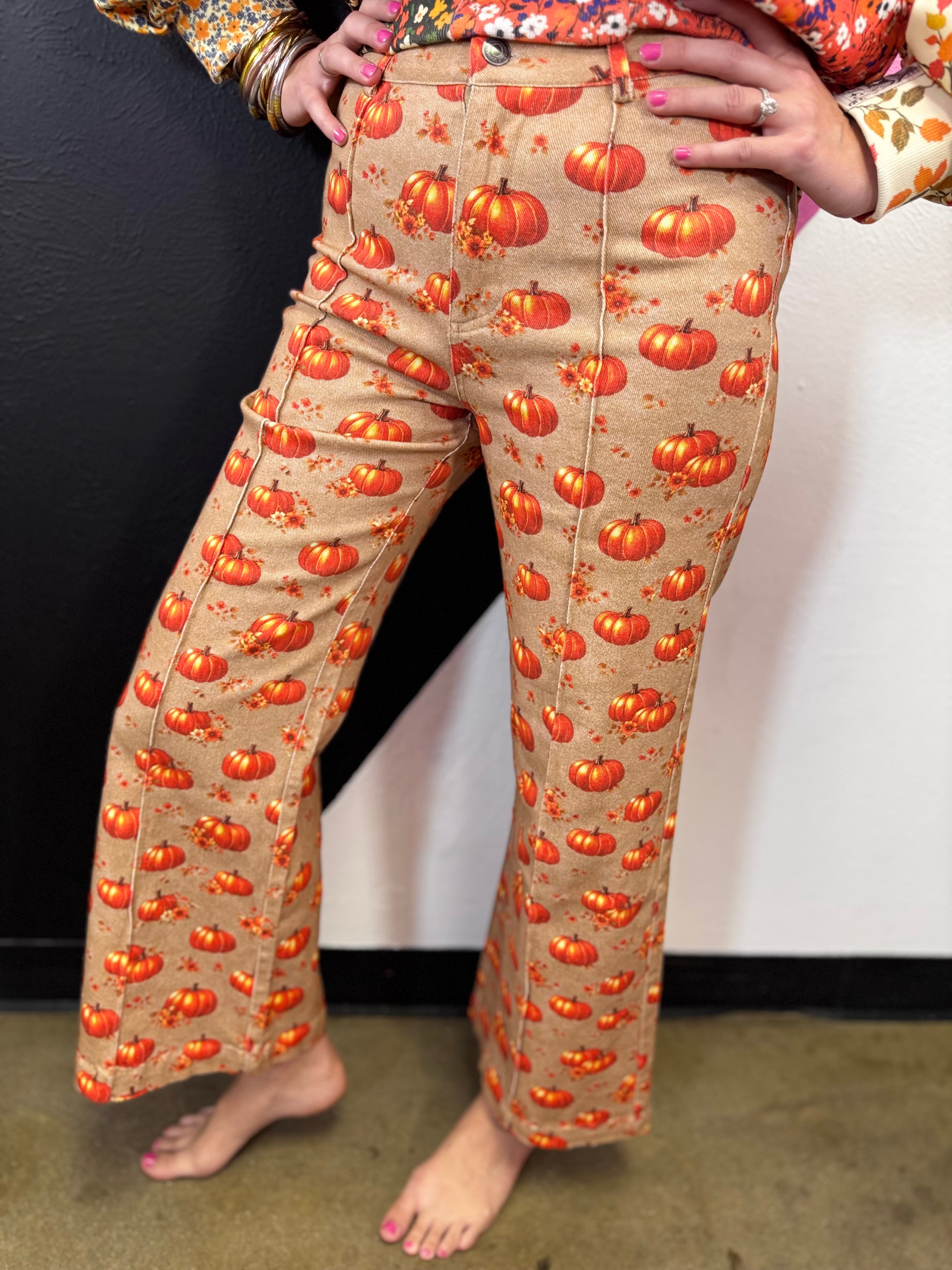 Latte stretch denim pants with orange pumpkins, autumn florals, and cropped wide-leg flare.