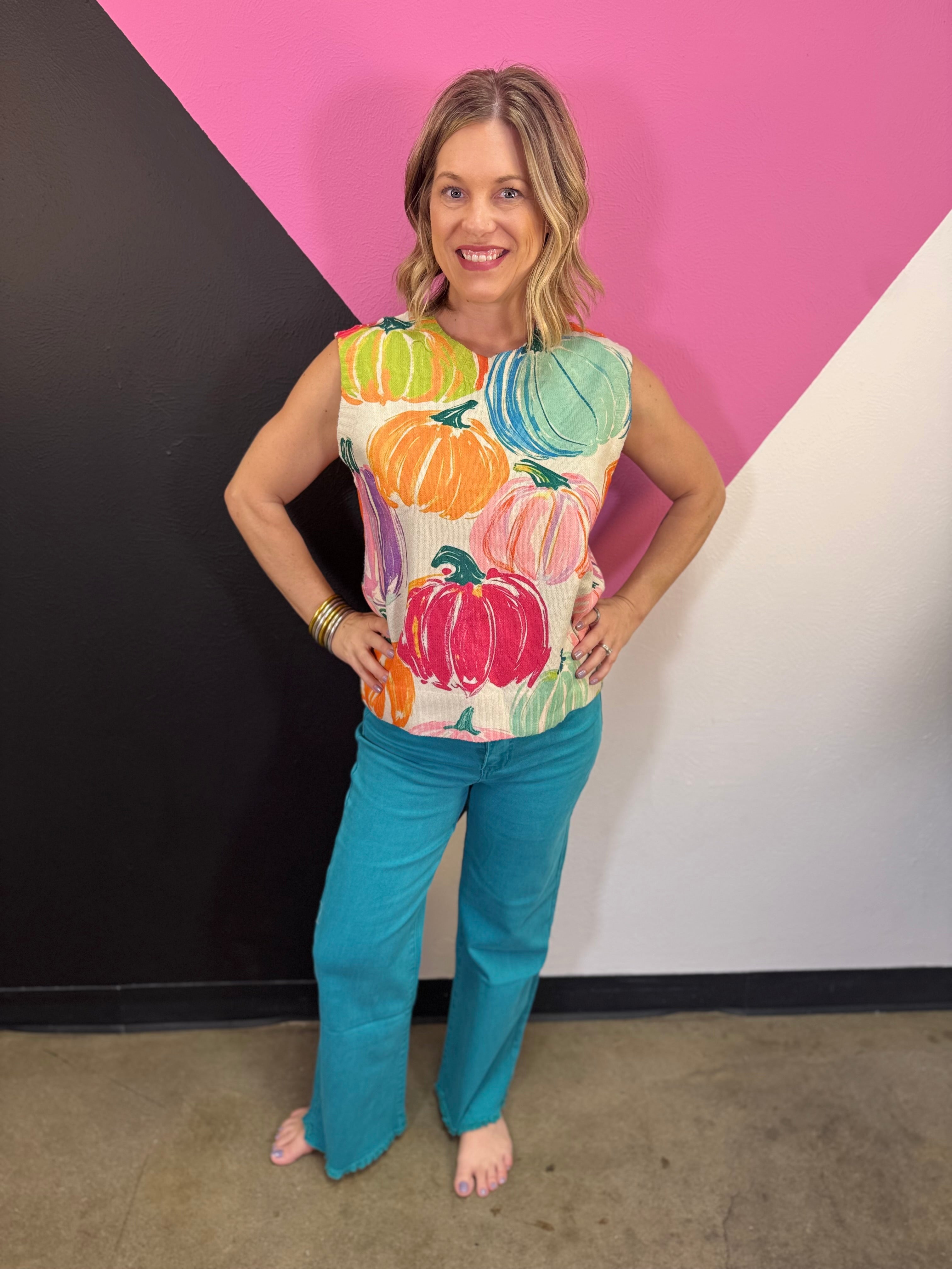 Cream sleeveless sweater with colorful watercolor pumpkin print and rounded neckline