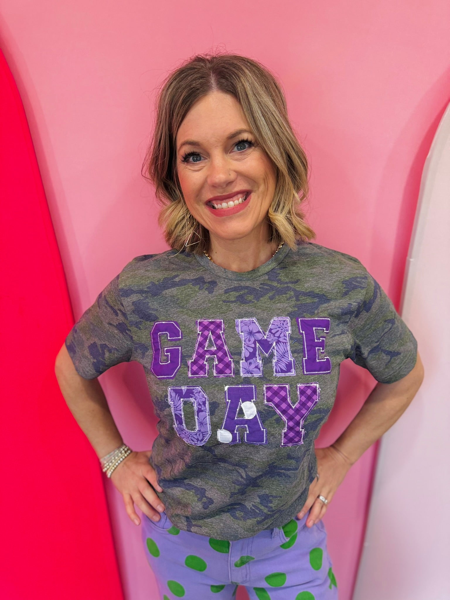 Purple Game Day tee with patchwork appliqué lettering and mixed purple print details.
