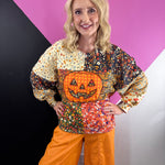 Colorful patchwork floral sweatshirt with oversized orange plaid jack-o'-lantern appliqué.