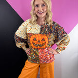 Colorful patchwork floral sweatshirt with oversized orange plaid jack-o'-lantern appliqué.
