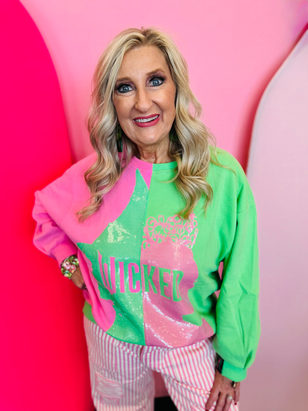 Queen of Sparkles Wicked Sweatshirt, green and pink colorblock with glittery character profile graphic.
