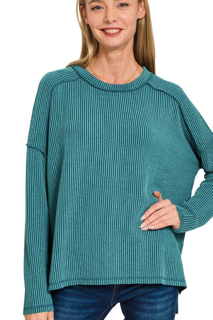 Plus-size teal ribbed boat neck long sleeve top with raw edge detailing.