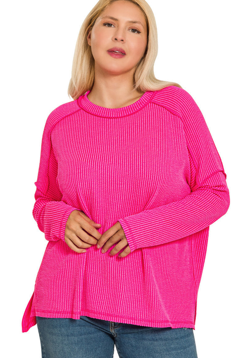 Plus-size hot pink ribbed boat neck top with raw edge detail and long sleeves.