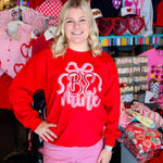 Red pullover sweatshirt with Be Mine applique, side slits, and bow detail.