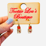Red and clear gemstone drop earrings with gold hardware and faceted stones.