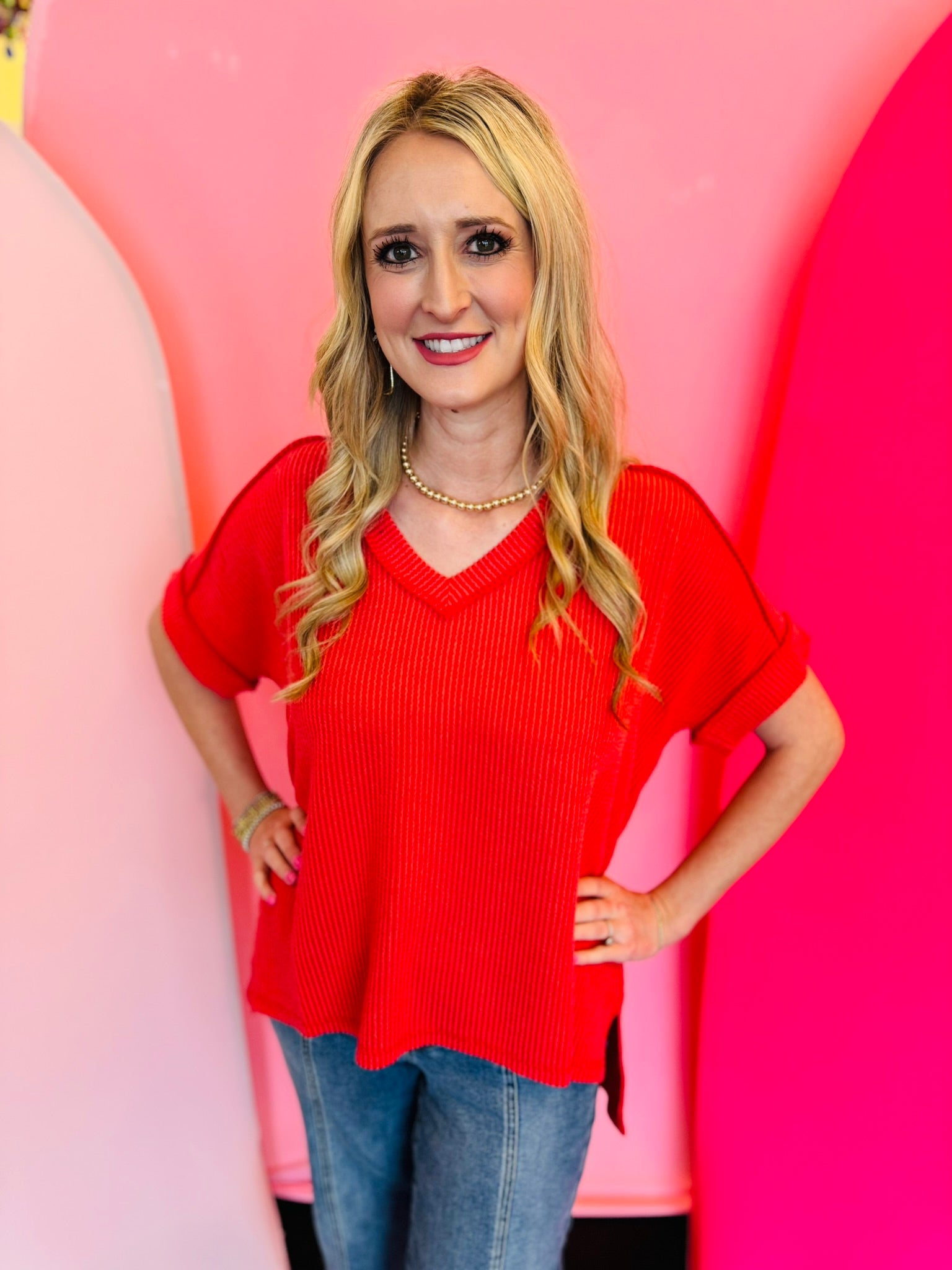 Red corded rib knit top with relaxed fit and hi-low V-neck.